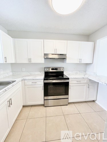 A kitchen with white cabinets and a stainless steel oven.