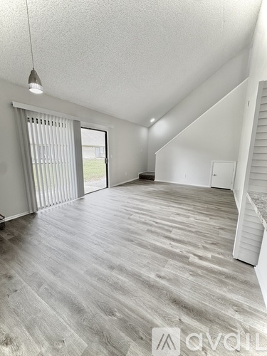 A spacious room with a grey floor and white walls.