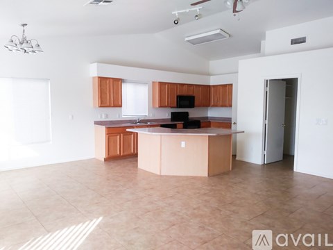 A kitchen with brown cabinets and a black microwave.