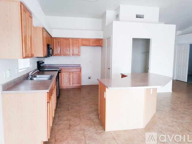 A kitchen with wooden cabinets and a white island.