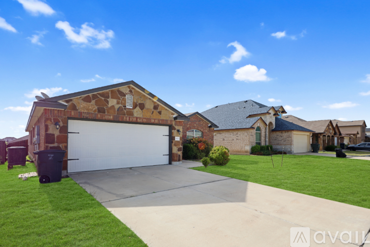 A house with a garage and a driveway in front of it.