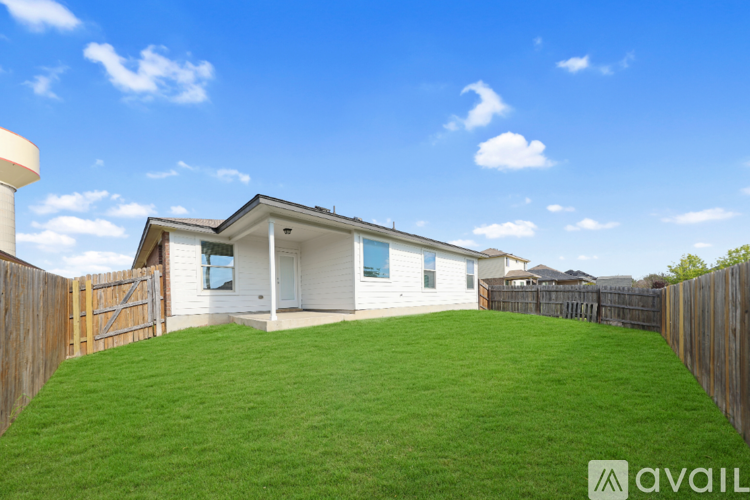 A house with a white exterior and a green lawn is for sale.