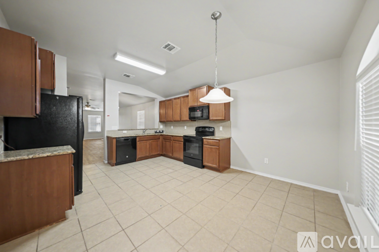 A kitchen with wooden cabinets and black appliances.