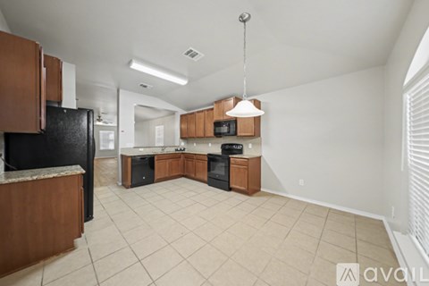 A kitchen with wooden cabinets and black appliances.
