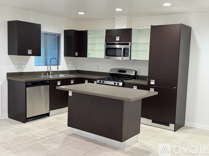 A modern kitchen with dark brown cabinets and a central island.