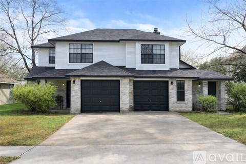 A two-story house with a garage is available for sale.