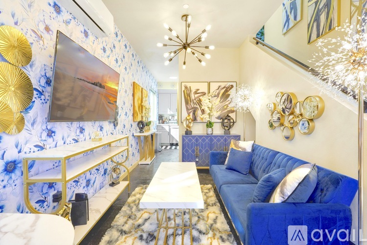 A living room with a blue couch and gold decorations.