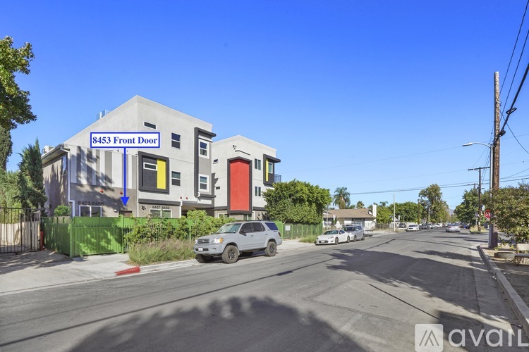 A street view with a building that has a sign saying "8453 Front Door".