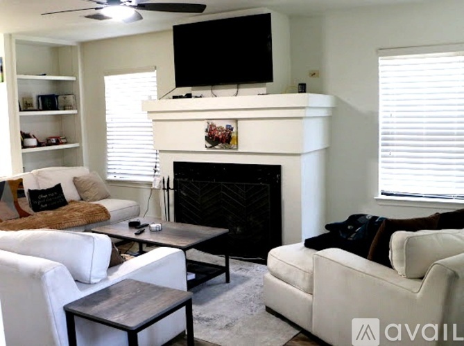 A living room with a fireplace, two couches, and a television.