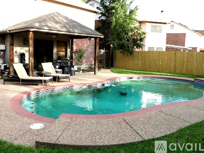 A pool with a gazebo in the backyard.