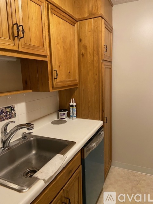 A kitchen with wooden cabinets and a white countertop.