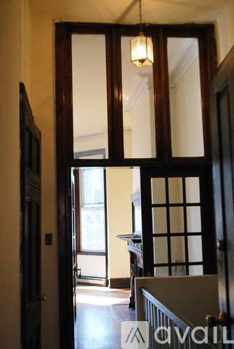 A room with a wooden floor and a large mirror on the wall.