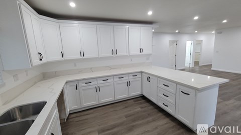 A kitchen with white cabinets and a sink.
