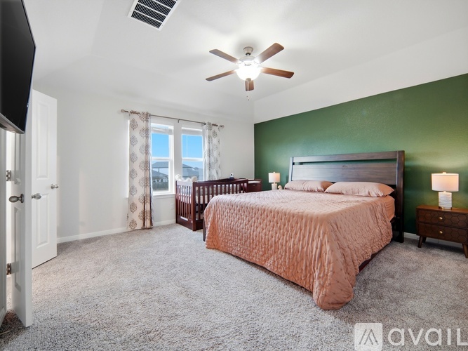 A bedroom with a large bed and a ceiling fan.