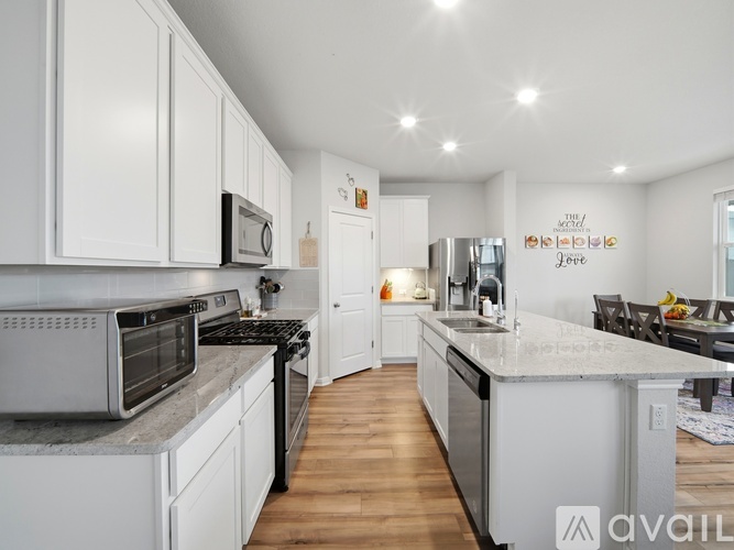 A modern kitchen with white cabinets and stainless steel appliances.