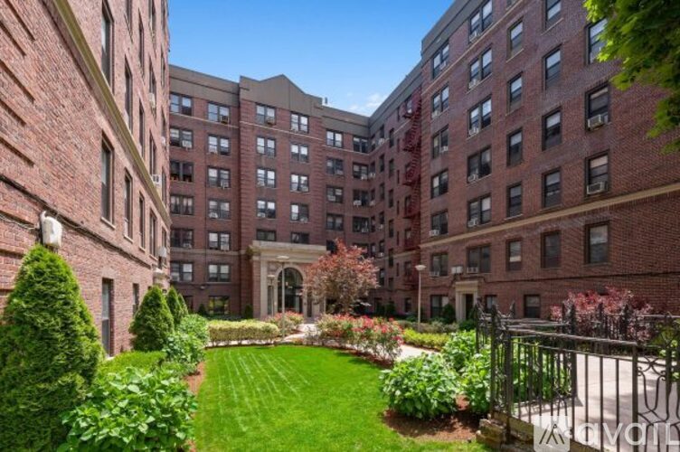 A brick building with a green lawn in front.