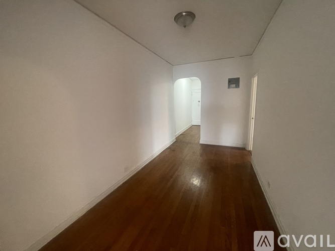 A long hallway with wooden floors and white walls.