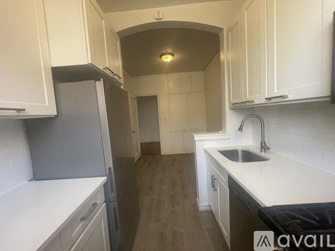 A kitchen with white cabinets and a sink.