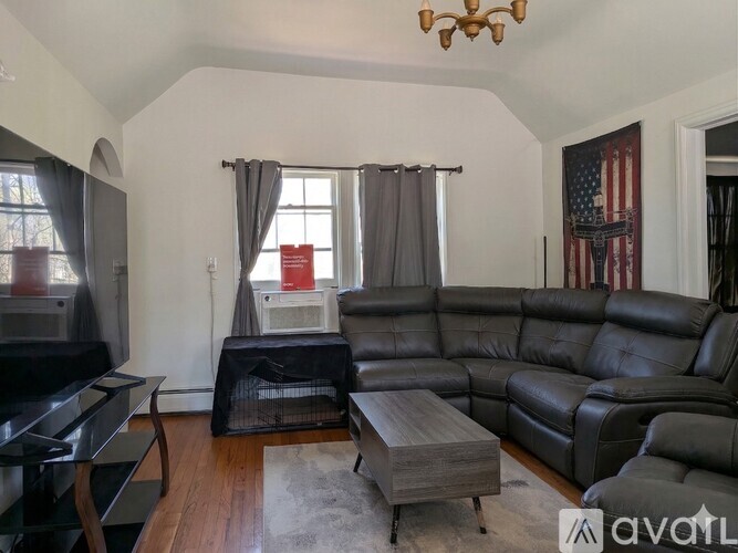 A living room with a black leather couch and a coffee table.