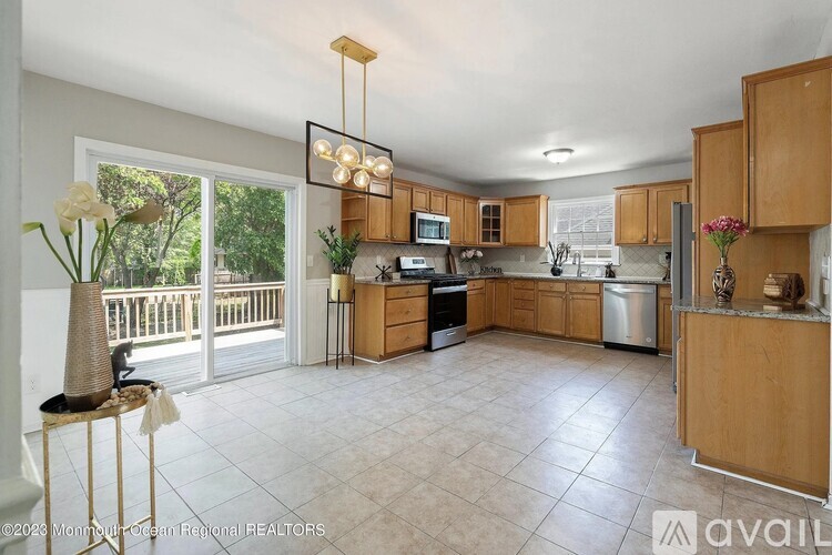 A kitchen with wooden cabinets and a large island with a sink.