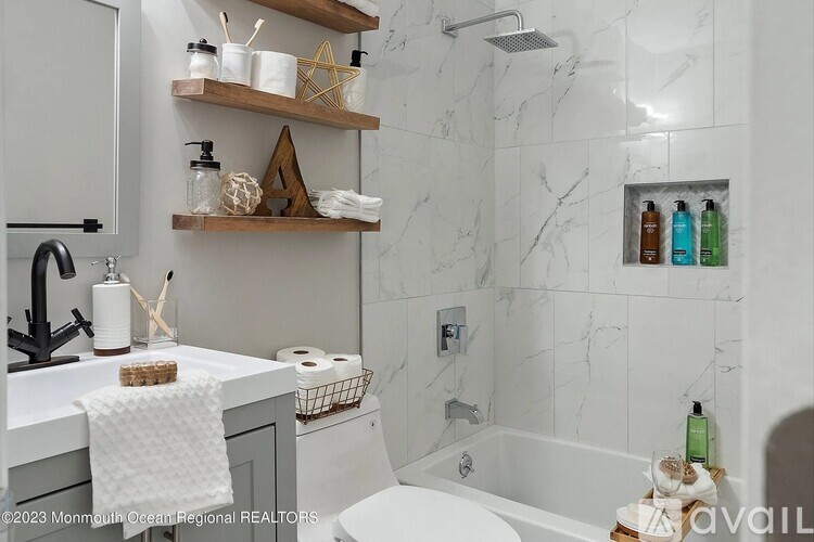 A bathroom with a marble wall and a white toilet.