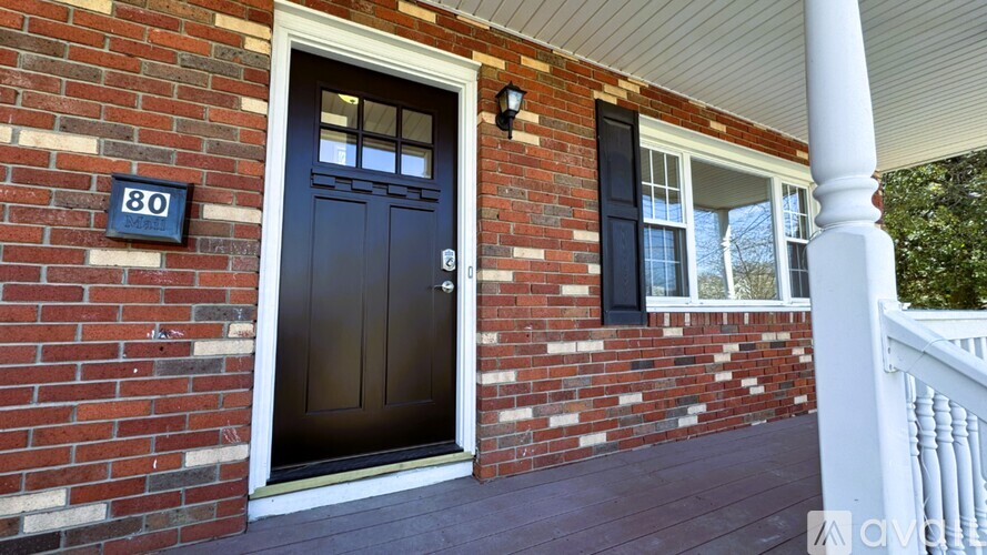 A house numbered 80 with a black door and windows.