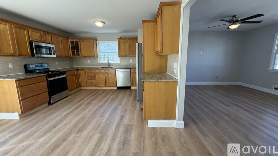 A kitchen with wooden cabinets and a microwave on the counter.