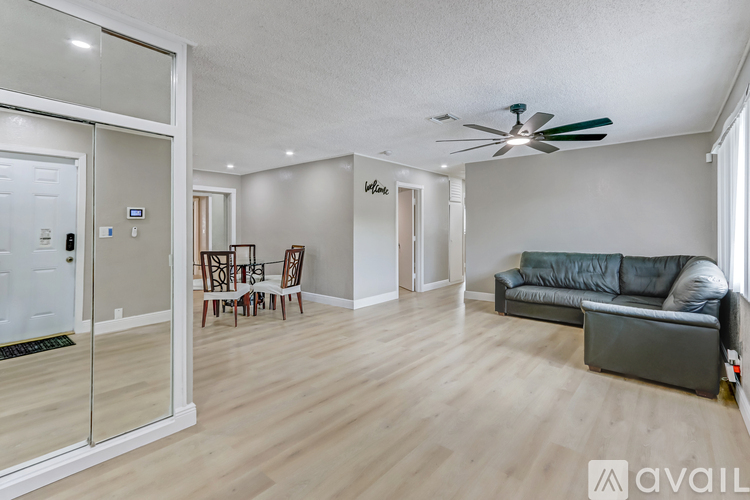 A living room with a grey couch and a ceiling fan.