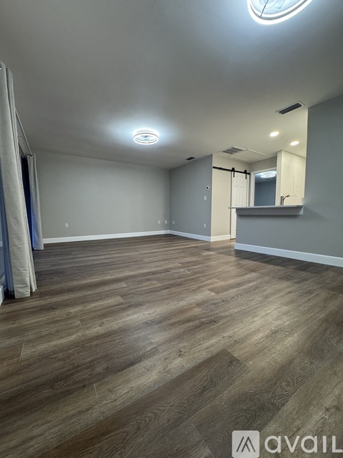 A room with wooden flooring and a mirror on the wall.