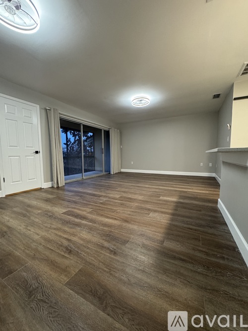 A room with wooden flooring and a ceiling fan.