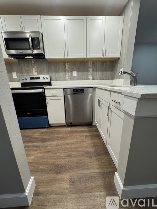 A kitchen with a stove, dishwasher, and microwave.