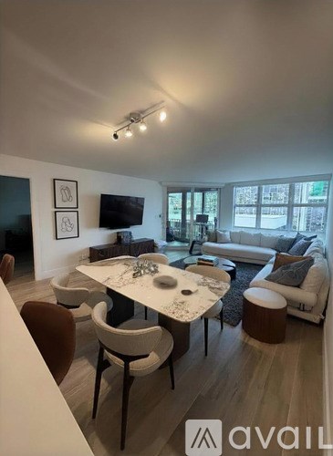 A modern living room with a dining table and chairs.