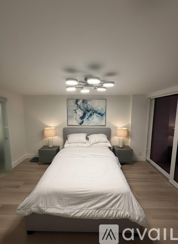 A bedroom with a large bed and a ceiling fan.