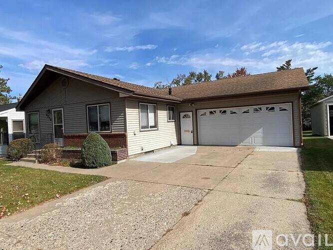 A house with a grey garage door and a brown roof.
