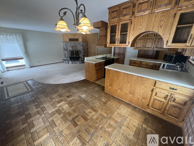 A kitchen with wooden cabinets and a stone fireplace.