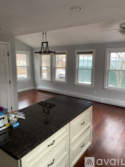 A kitchen with a black countertop and white cabinets.