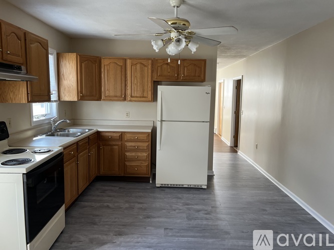 A kitchen with wooden cabinets and a white refrigerator.