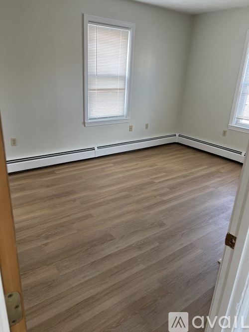 A room with wooden flooring and a window.