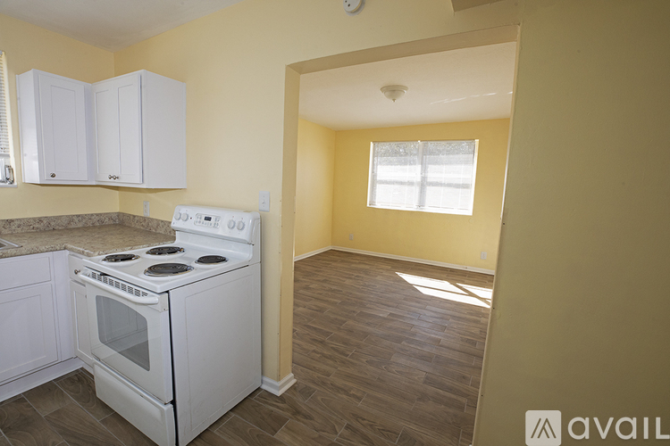 A kitchen with a white stove and cabinets.