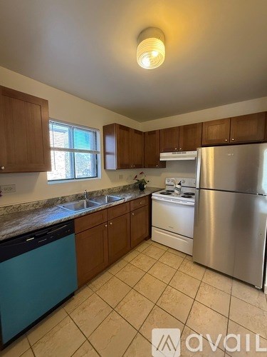 A kitchen with wooden cabinets and a stainless steel refrigerator.