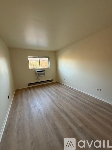 A room with wooden flooring and a window.