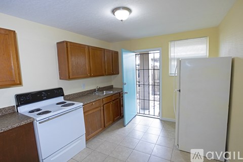 A kitchen with a white stove and wooden cabinets.