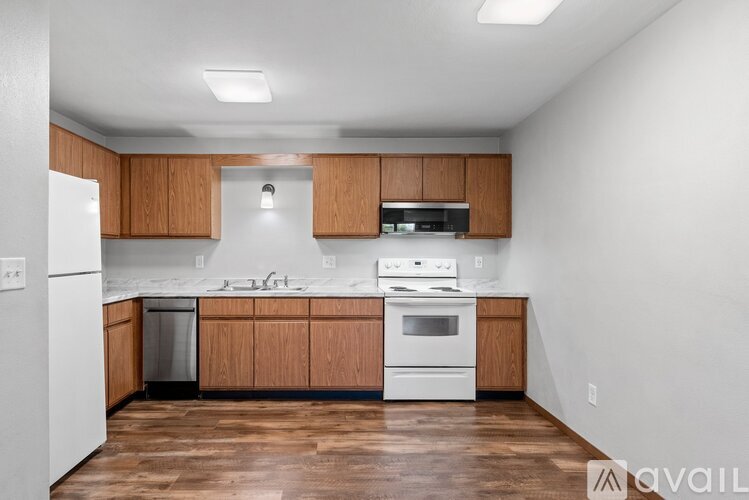 A kitchen with wooden cabinets and white appliances.
