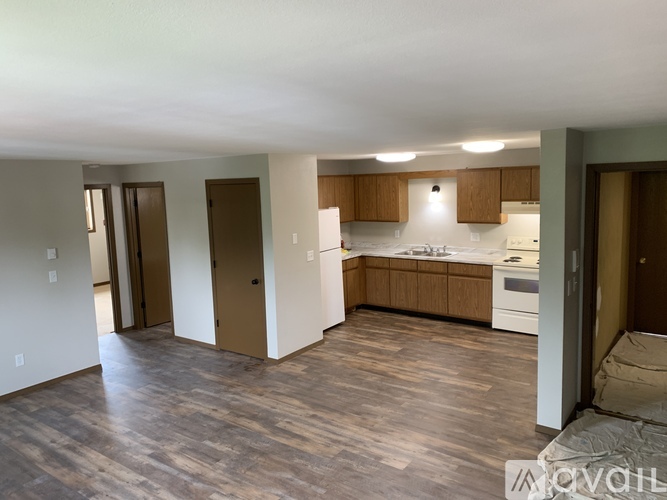A kitchen with wooden floors and white walls.