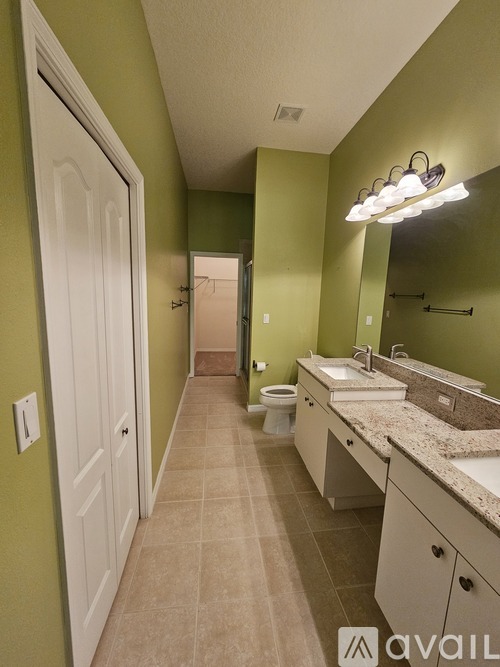 A bathroom with green walls and a white door.