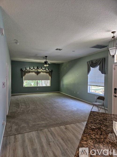 A room with a window and a fan on the ceiling.