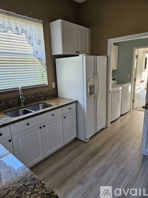 A kitchen with a white fridge and cabinets.