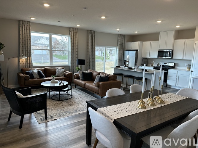 A modern living room with a kitchen in the background.