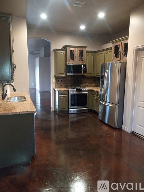 A kitchen with a granite counter top and stainless steel appliances.