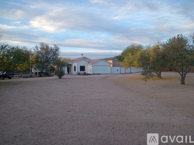 A house with a yard and trees in the background.